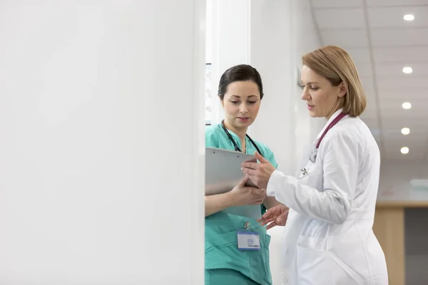 成熟的医生与护士讨论在医院剪贴板上的医疗报告 — 图库照片