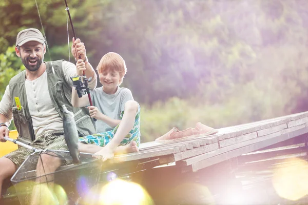 在湖岸蝴蝶渔网中钓鱼的快乐父子的倾斜镜头 — 图库照片