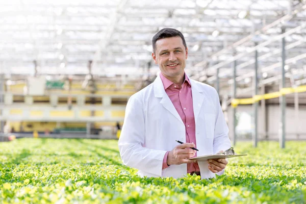 Portret Van Lachende Wetenschapper Permanent Met Klembord Temidden Van Kruiden — Stockfoto