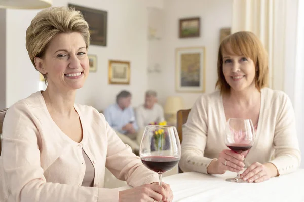 Portret Van Lachende Volwassen Vrouwen Zitten Met Winegasse Eettafel — Stockfoto