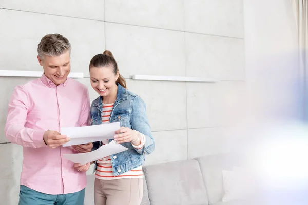 Glimlachend Paar Lezen Overeenkomst Papieren Terwijl Staande Tegen Muur Appartement — Stockfoto