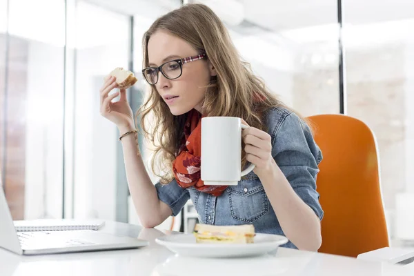 Empresaria Que Usa Computadora Portátil Mientras Desayuna Oficina —  Fotos de Stock