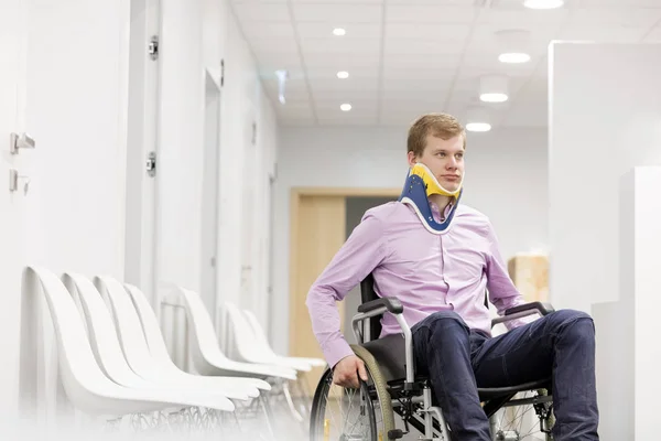 Junger Mann Mit Nackenstütze Sitzt Rollstuhl Auf Krankenhausflur — Stockfoto