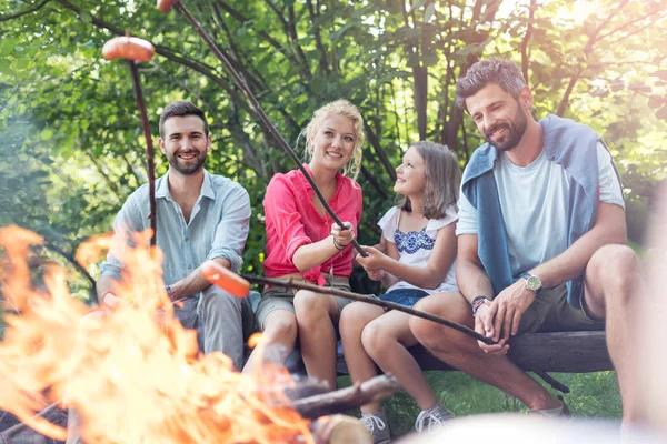 Gelukkige Familie Met Mannelijke Vriend Roosteren Worst Kampvuur Park — Stockfoto