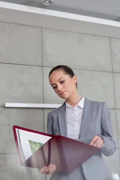 Confiado Joven Agente Inmobiliario Femenino Leer Documento Contra Pared Apartamento — Foto de Stock