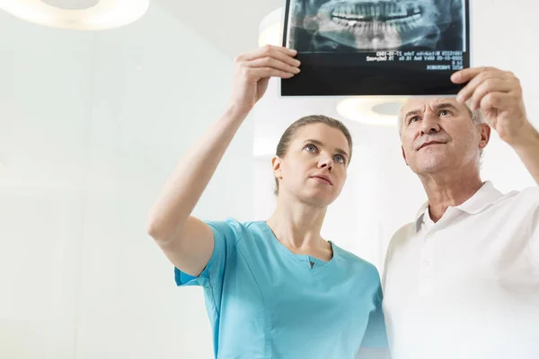 Уверенные Мужчины Женщины Дантисты Осматривают Рентген Клинике — стоковое фото