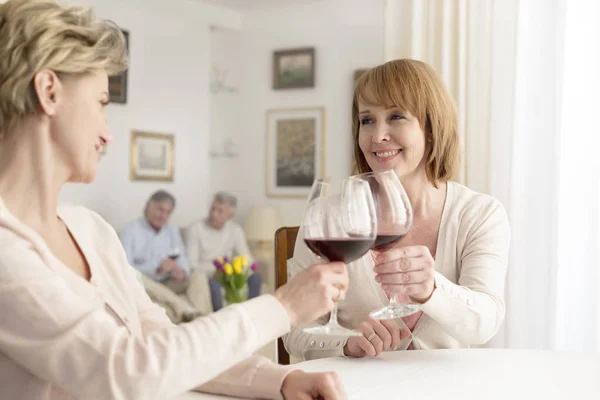 Donne Sorridenti Tostare Bicchieri Vino Mentre Seduti Tavola — Foto Stock