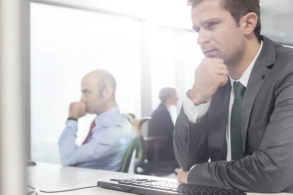 Doordachte Zakenlieden Die Werken Terwijl Aan Bureau Modern Kantoor Zitten — Stockfoto