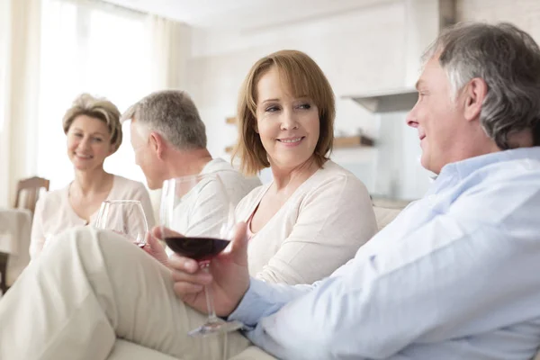 Usmívající Starší Přátelé Mluví Zatímco Sedí Pohovce Obývacím Pokoji Doma — Stock fotografie