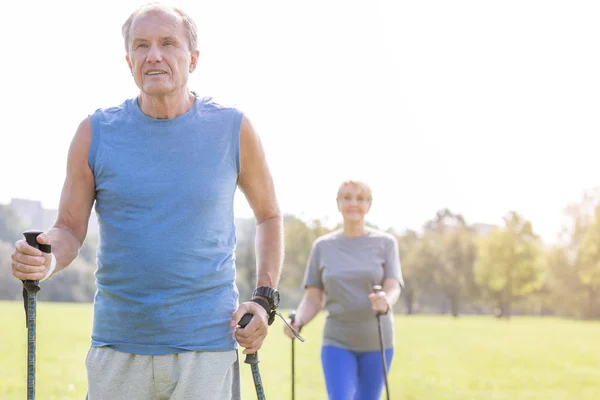 Ajuste Macho Senior Usando Bastones Trekking Con Mujer Parque —  Fotos de Stock