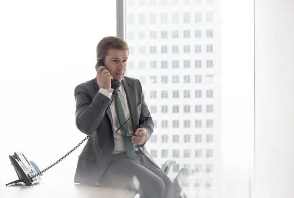Empresário Falando Telefone Enquanto Sentado Mesa Escritório — Fotografia de Stock
