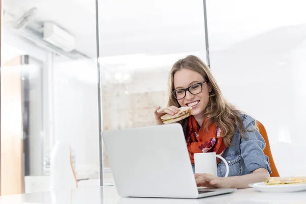 Kreativa Affärskvinna Äter Frukost Medan Arbetar Med Laptop Office — Stockfoto