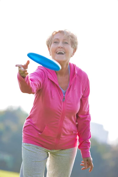 Uśmiechający Się Zdrowy Senior Kobieta Rzucając Płyty Parku — Zdjęcie stockowe