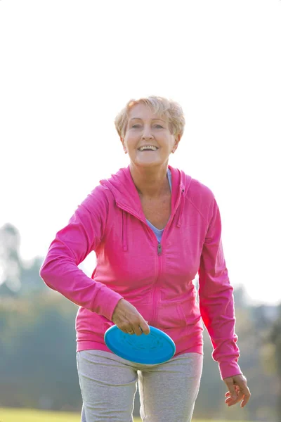 Sorridente Sana Donna Anziana Lancio Del Disco Nel Parco — Foto Stock