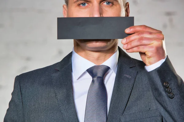 Reifer Geschäftsmann Bedeckt Mund Mit Papier Gegen Weiße Ziegelwand Büro — Stockfoto