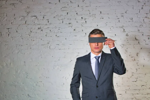 Volwassen Zakenman Bedekt Ogen Met Papier Tegen Witte Bakstenen Muur — Stockfoto