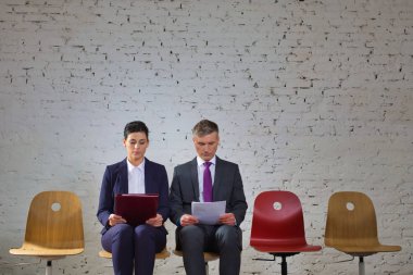 Belgeleri okurken tuğla duvara yaslanmış bir iş hücresi