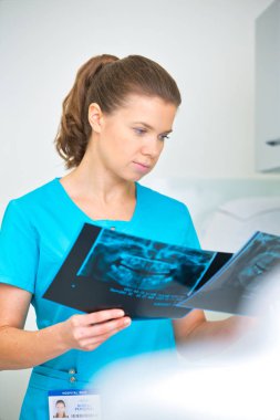 Kendine güvenen doktor diş kliniğinde tıbbi x-ray incelenmesi