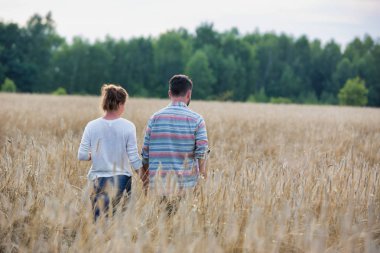 Çiftlikteki ekinlerin arasında yürüyen çiftlerin dikiz görüntüsü