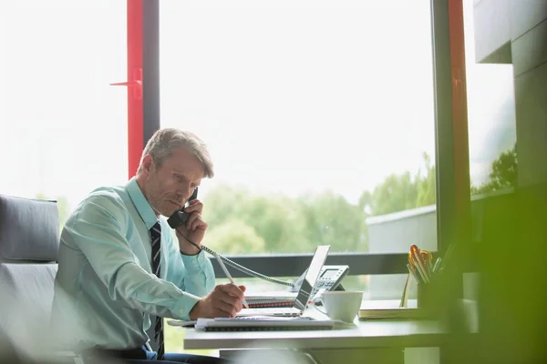 Lachende Zakenman Praten Telefoon Terwijl Het Gebruiken Van Laptop Aan — Stockfoto