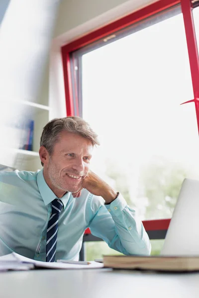 Sonriente Hombre Negocios Usando Ordenador Portátil Mientras Hace Papeleo Escritorio — Foto de Stock