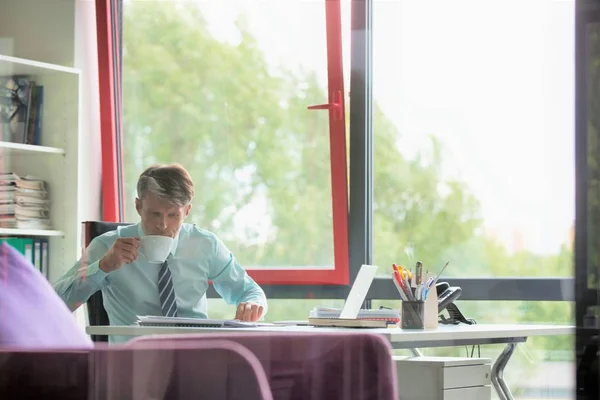 Gerçek Bir Adamı Ofisinde Çalışıyor Akıllı Telefon Kullanıyor Sabah Kahvesini — Stok fotoğraf