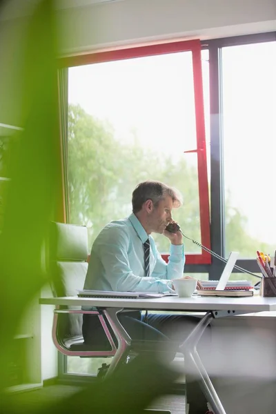 Seriöser Geschäftsmann Telefoniert Mit Laptop Schreibtisch Büro — Stockfoto