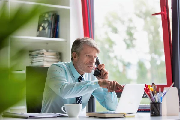 Homem Negócios Sério Falando Por Telefone Usar Laptop Mesa Escritório — Fotografia de Stock