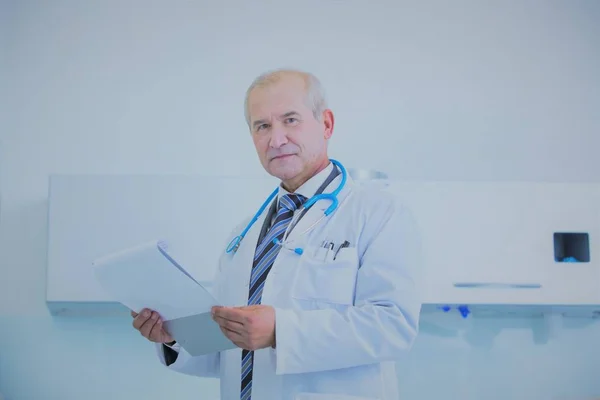 Portrait of smiling senior doctor with clipboard at dental clini — Photo