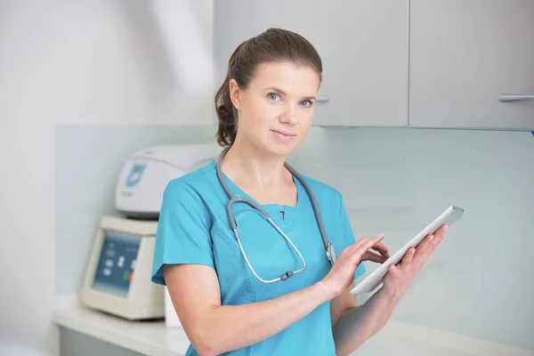 Médico sonriente usando tableta digital en clínica dental — Foto de Stock