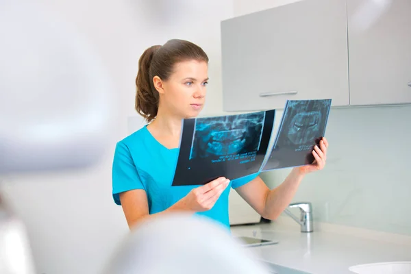 Confident doctor examining medical x-ray at dental clinic — Stock Photo, Image