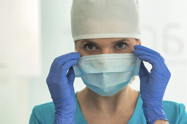 Retrato de encerramento do médico feminino usando máscara cirúrgica e tampa — Fotografia de Stock