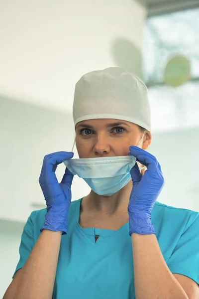 Porträt einer Ärztin entfernt Chirurgenmaske in Klinik — Stockfoto