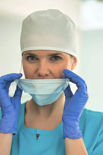 Retrato do médico feminino removendo máscara cirúrgica na clínica — Fotografia de Stock