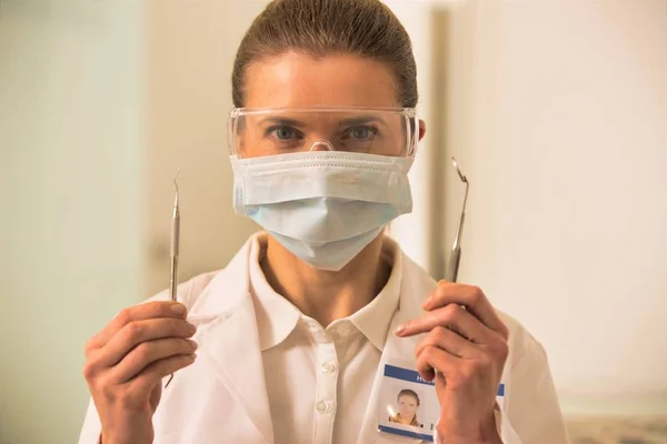 Retrato de dentistas confiados que usan mascarilla quirúrgica y vestimenta de los ojos. — Foto de Stock