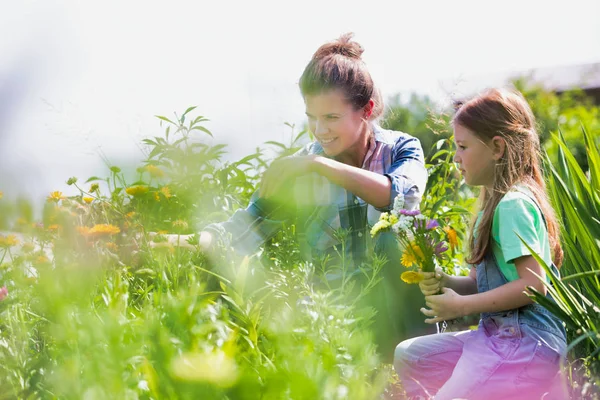 Sonrientes Madre Hija Mirando Flores Mientras Cultivan Huerto Granja — Foto de Stock