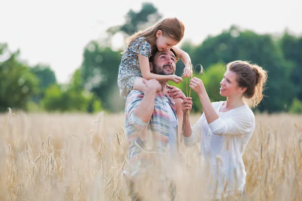 農場で妻と一緒に立っている間に娘を運ぶ男 — ストック写真