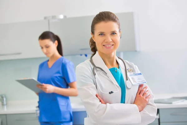 Portrait of confident doctor standing against nurse at clinic Stock Picture