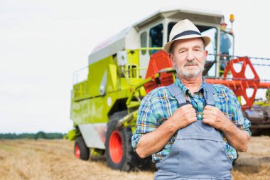 Kendine güvenen üst düzey Çiftçi traktör çiftliğinde karşı daimi portresi