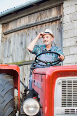Çiftlikte traktör kullanan kendine güvenen çiftçi