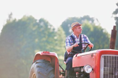 Çiftlikte traktör kullanan kendine güvenen çiftçi