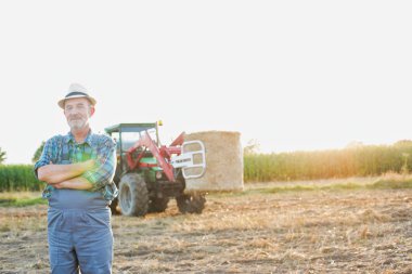Kendine güvenen üst düzey Çiftçi traktör çiftliğinde karşı daimi portresi