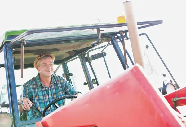 有信心的农民在农场驾驶拖拉机 — 图库照片