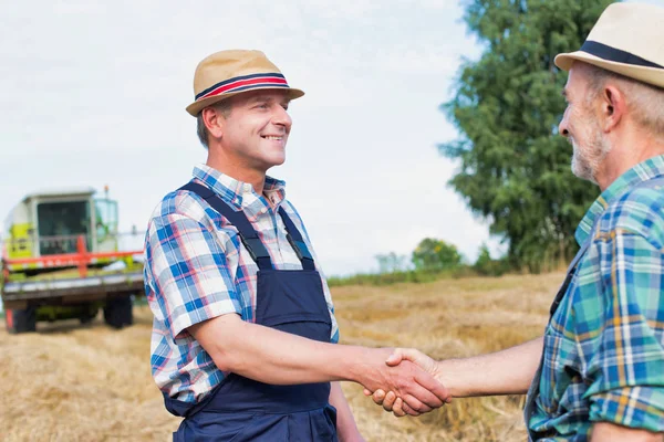农民们站在农场的地里握手 — 图库照片