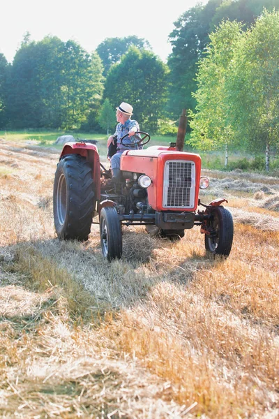 confident farmer driving tractor at farm