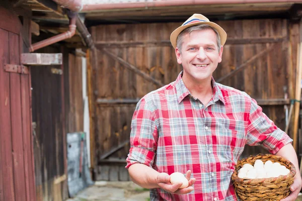 Usmívající Farmář Drží Čerstvá Vejce Proutěném Košíku Farmě — Stock fotografie