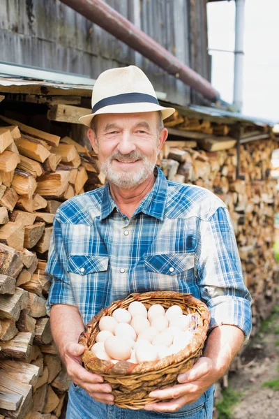 Usmívající Farmář Drží Čerstvá Vejce Proutěném Košíku Farmě — Stock fotografie