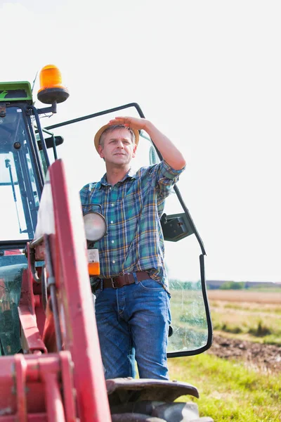 农夫站在田边的收割机上与天空抗衡 — 图库照片