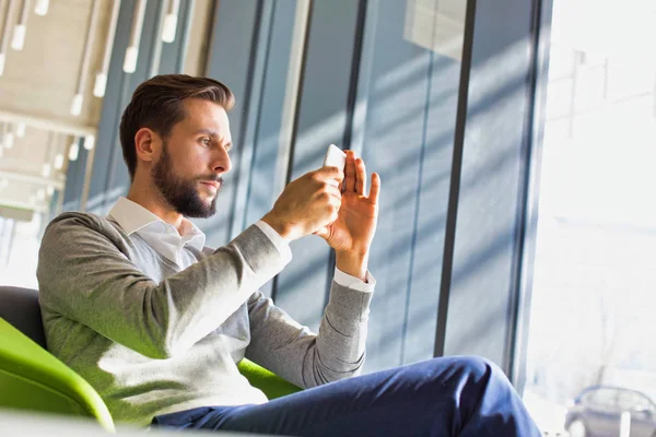 Empresário Barbeado Usando Telefone Inteligente Enquanto Sentado Cadeira Verde Área — Fotografia de Stock