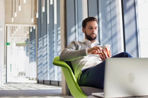 Bearded Businessman Using Smart Phone Whilst Sitting Green Chair Office — Stock Photo, Image